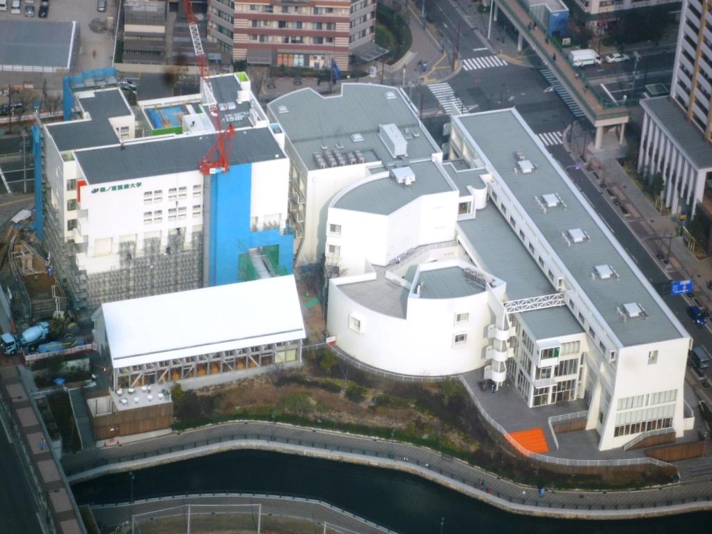 上空から見たキャンパス全景 上部：大阪港＆コスモスクエア駅（徒歩１分） 下部：キャナル運河＆グラウンド